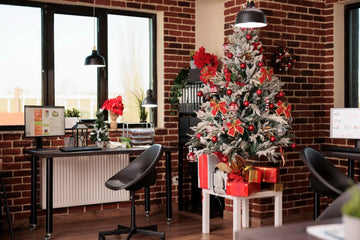 Festive flocked Christmas tree with red ornaments and gifts in a cozy brick-walled home office.