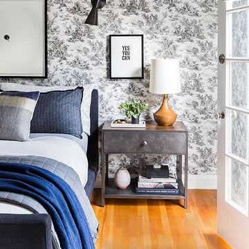 Stylish bedroom with floral wallpaper, modern nightstand, blue bedding, and framed wall art for home decor inspiration