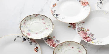 Elegant floral-patterned porcelain plates and saucers on marble surface for home decor