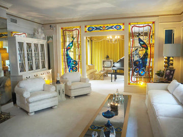 Elegant living room with peacock stained glass, white furniture, and luxury home decor accents