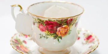Elegant floral teacup with gold trim, featuring rose design and matching saucer for vintage home decor