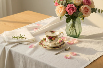 Elegant floral teacup set with roses and green vase on white tablecloth for home decor