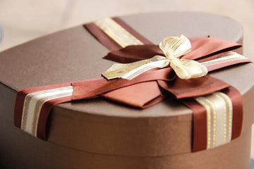 Elegant brown gift box with burgundy and gold ribbon bow, perfect for home decor gifting