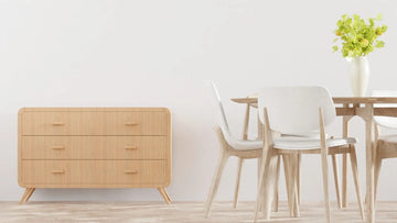 Modern wooden dresser and dining set with white chairs and greenery in minimalist home decor