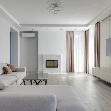 Modern living room with minimalist decor, neutral tones, fireplace, and large windows for natural light