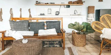 Cozy living room with wooden bench, wicker furniture, and tropical plants for home decor