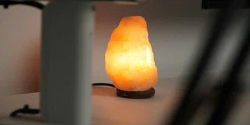 Glowing Himalayan salt lamp on wooden base, warm ambient lighting for cozy home decor