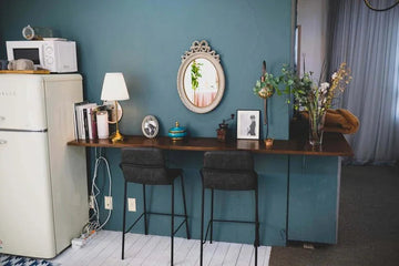 Stylish home bar setup with teal wall, vintage mirror, bar stools, and decorative accents for modern Queensland interiors