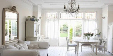 Elegant white living room with chandelier, mirror, and garden view for home decor inspiration
