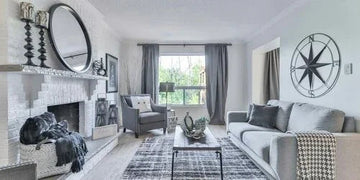 Modern living room with gray sofa, fireplace, compass wall art, and coastal decor for home styling