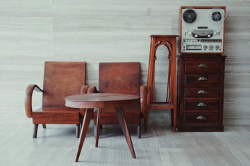 Vintage wooden chairs, table, and retro tape recorder in stylish home decor setup