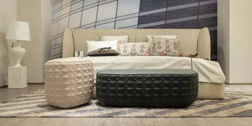 Modern bedroom with textured ottomans, patterned rug, and contemporary bed setup for stylish home decor