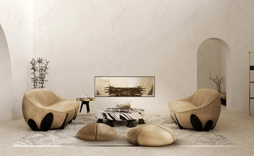 Modern beige armchairs with black accents, zebra-print coffee table, and abstract art in minimalist living room