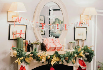 Festive Christmas mantel with garland, gifts, and 'Merry Christmas' banner for holiday home decor