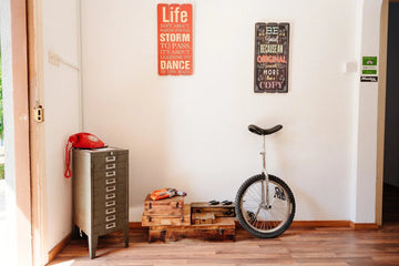 Vintage red phone on metal cabinet, wooden crates, and unicycle with motivational wall signs in cozy home decor