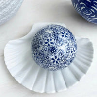 Blue and white floral porcelain decorative ball on white ceramic shell dish, home décor