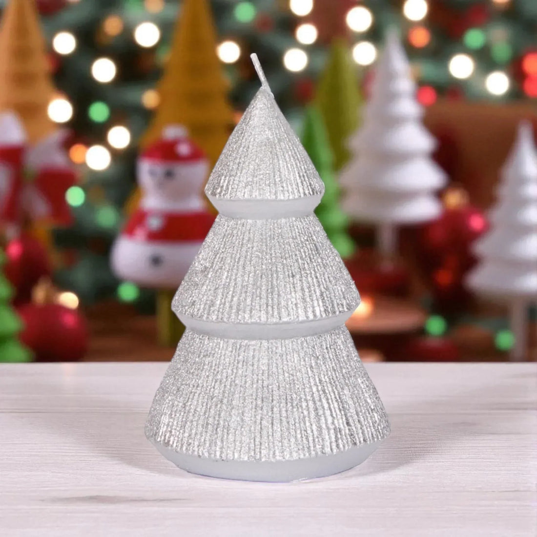 Sparkling silver Christmas tree candle with festive holiday decor background, perfect for seasonal home decoration.