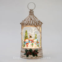 Birch-style lantern with glowing snow globe, snowmen, trees, and pinecones for festive home décor