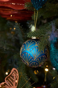 Blue and gold glitter Christmas ornament with Art Deco fan design hanging on tree