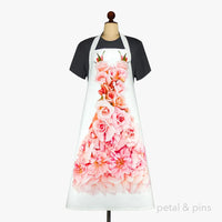 White apron with pink rose floral print, displayed on mannequin for kitchen or cooking use