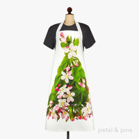 White apron with pink and white floral print, green leaves, displayed on mannequin for kitchen decor