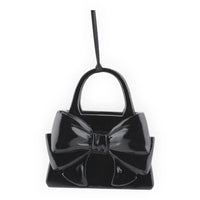 Glossy black handbag ornament with large bow, perfect for home décor or festive hanging display.