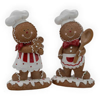 Gingerbread chef figurines with aprons, one holding a cookie, festive holiday home decor
