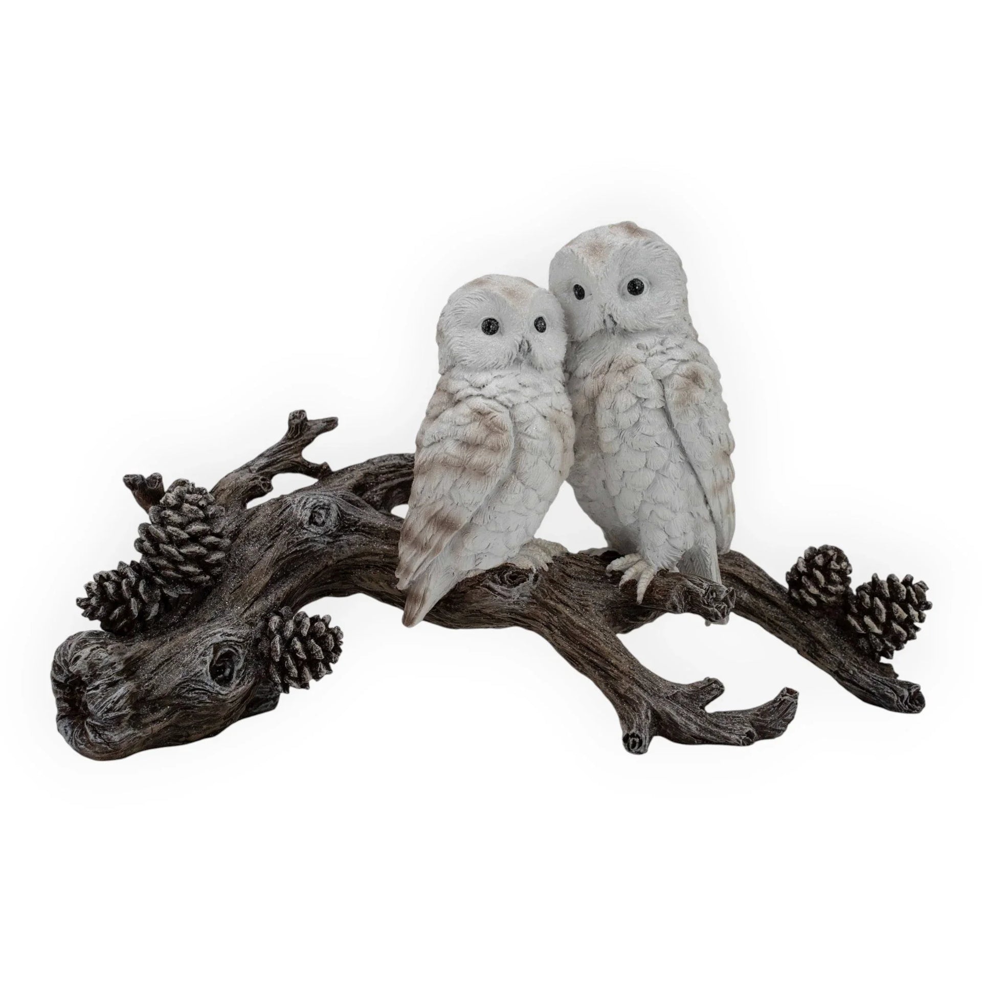 Two white owl figurines perched on a rustic branch with pinecones, perfect for home décor or vintage-inspired interiors.