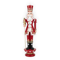 Red and gold nutcracker soldier figurine with crown, scepter, and festive holiday decor details