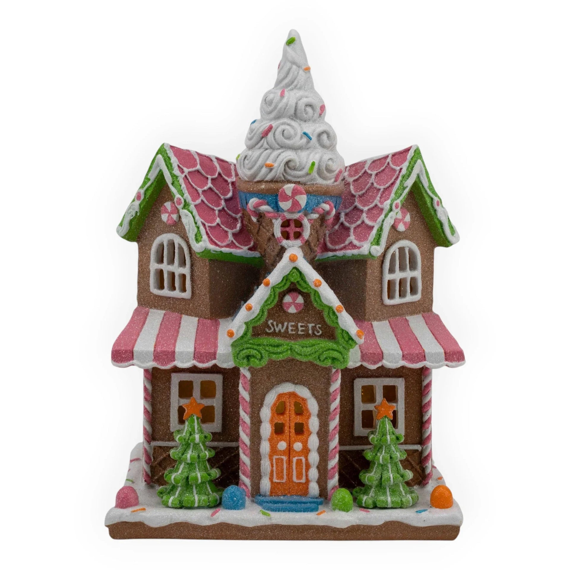 Gingerbread sweets shop with candy canes, pink roof, and ice cream cone tower, festive holiday décor