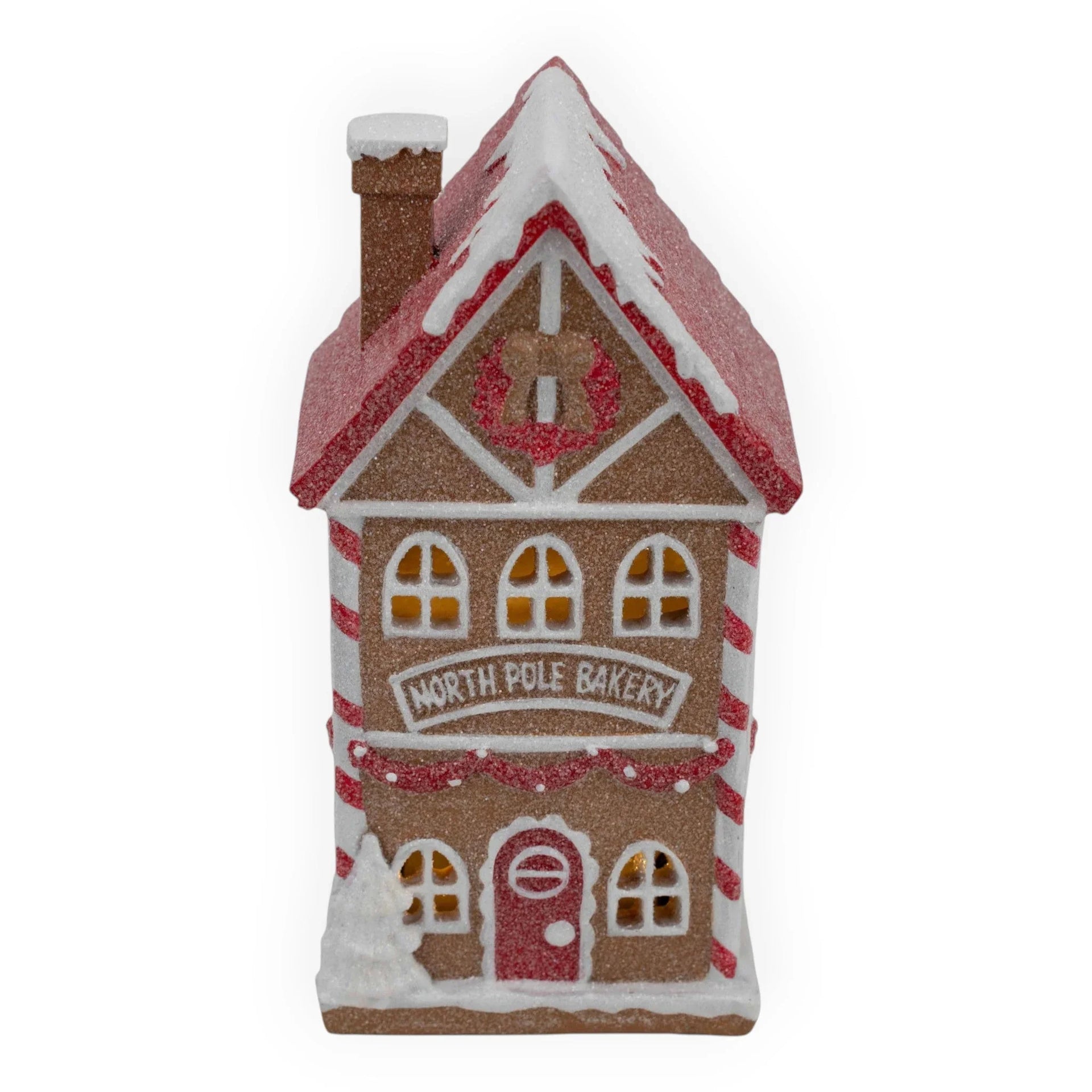 Gingerbread North Pole Bakery house with red roof, candy cane stripes, and glowing windows for Christmas décor