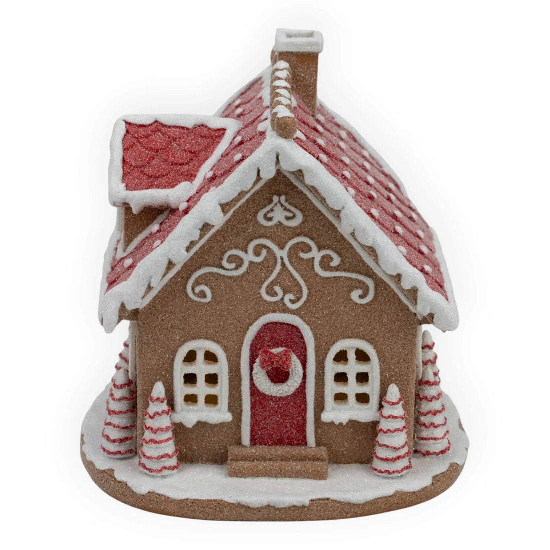 Gingerbread house decoration with red roof, white icing, and festive trees for holiday home décor