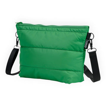 Green quilted crossbody bag with black strap and base tag, stylish everyday accessory