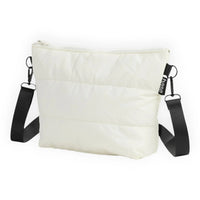 Cream quilted crossbody bag with black strap and base tag, minimalist design for everyday use