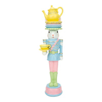 Pastel rabbit nutcracker holding teacup, topped with teapot, perfect for vintage home décor and Easter displays.