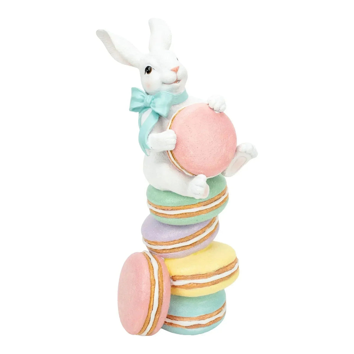 White bunny figurine with mint bow holding pink macaron, perched on pastel macaron stack for Easter home decor