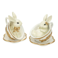 Charming white bunny figurines in gold-trimmed teacups, perfect for vintage home décor and Easter displays.