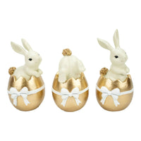 White bunny figurines in gold Easter eggs with white bows, home décor set