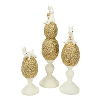 White bunny figurines perched on gold floral egg pedestals, elegant home decor set