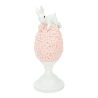 White bunny figurine perched atop pink floral egg on pedestal, elegant home décor accent piece