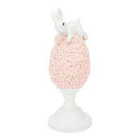 White bunny figurine perched atop pink floral egg on pedestal, elegant home décor accent piece