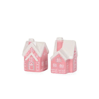 Pink ceramic gingerbread house ornaments with white roofs, perfect for festive home décor and holiday styling.