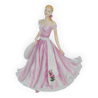 Elegant porcelain figurine of woman in pink and white gown with rose detail, vintage home décor accent