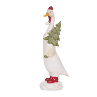 White goose figurine wearing Santa hat and red boots, holding a glittery Christmas tree, festive home décor