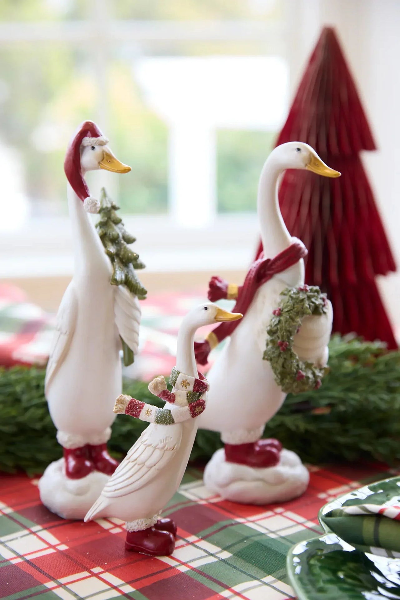 Festive white duck figurines with Santa hats, scarves, and boots, perfect for Christmas home décor and holiday table settings.