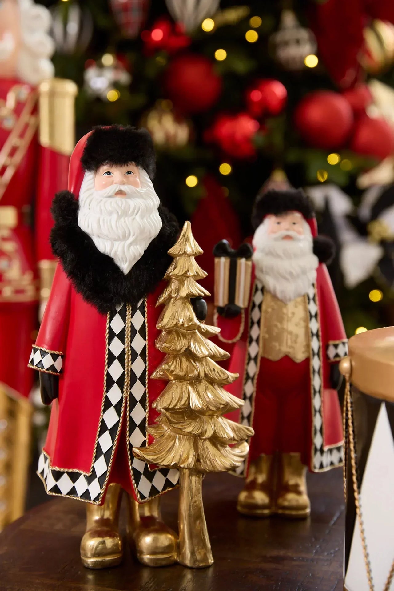 Festive Santa figurine with gold tree, red coat, black fur trim, and harlequin pattern, holiday home décor