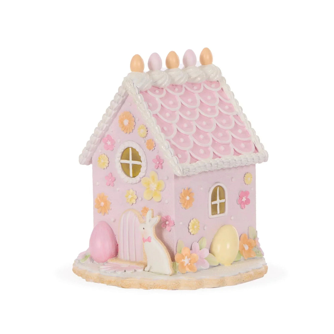 Pink Easter bunny house with pastel eggs, flowers, and scalloped roof for spring home décor
