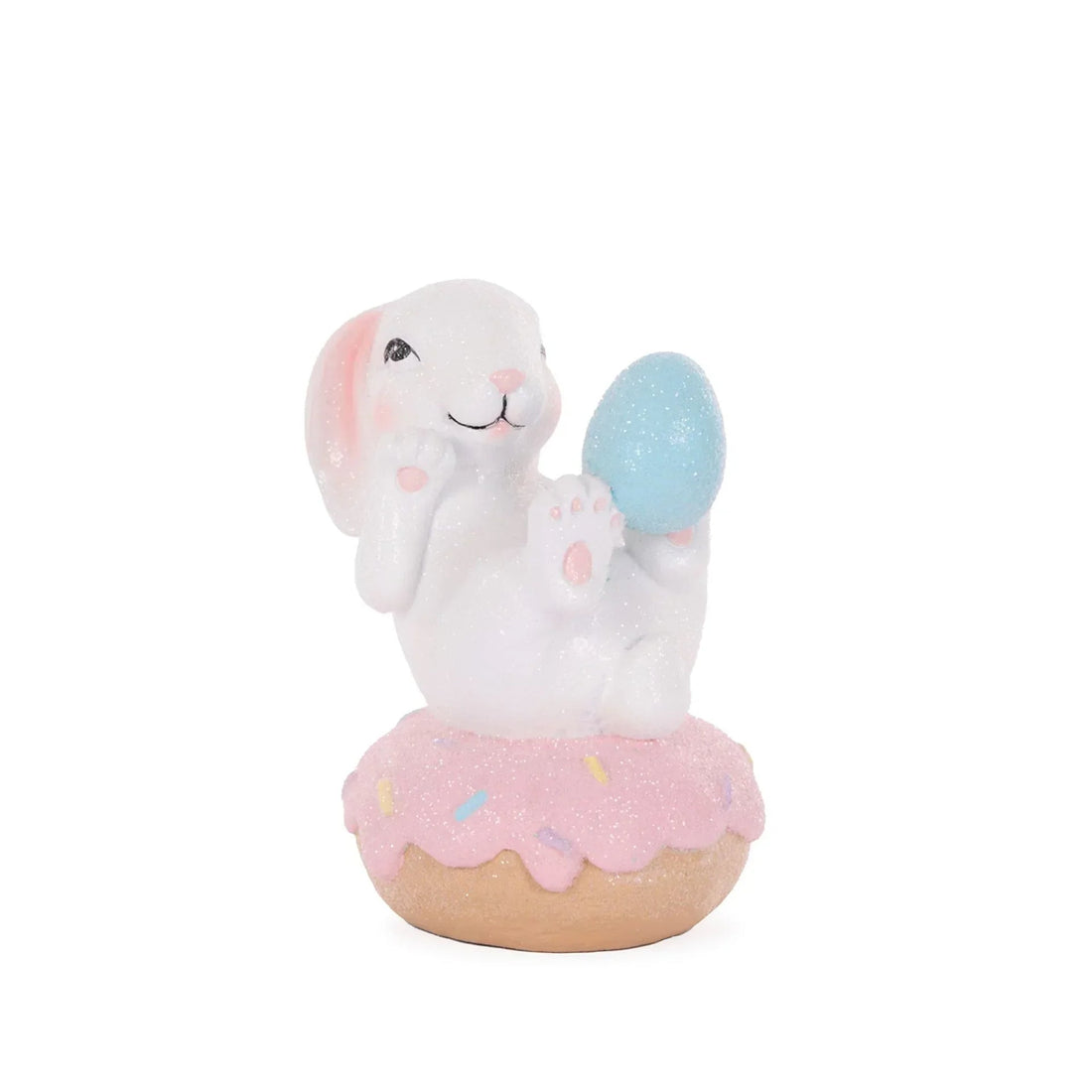Glittery white bunny holding blue egg, sitting on pink donut with sprinkles, Easter home decor