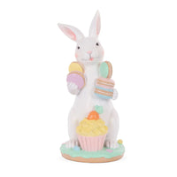 White glitter bunny figurine holding pastel macarons and a cupcake with carrot topper, Easter home decor