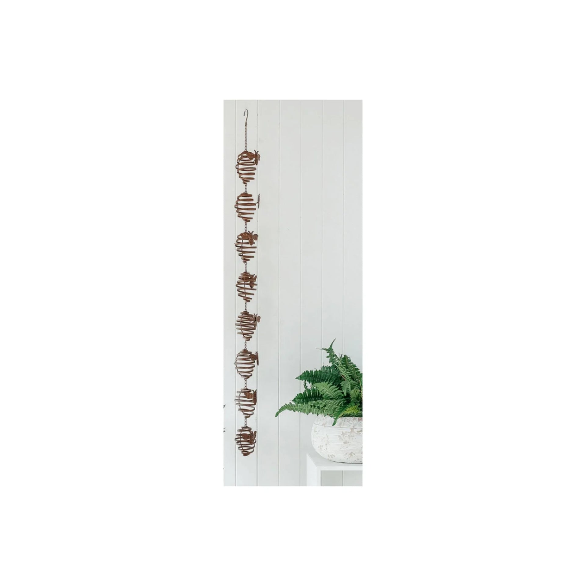 Rustic metal spiral wall hanging with leaf accents, perfect for vintage home décor and farmhouse style interiors.